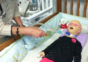 nurse practices suctioning technique on a pediatric simulation mannequin