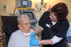 Clinician placing Passy Muir Valve on patient